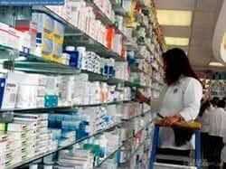 Una mujer está de pie en una escalera en una farmacia.