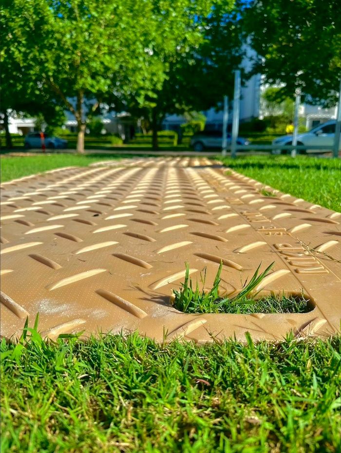 Image of Track mats lay out over some uneven  ground.