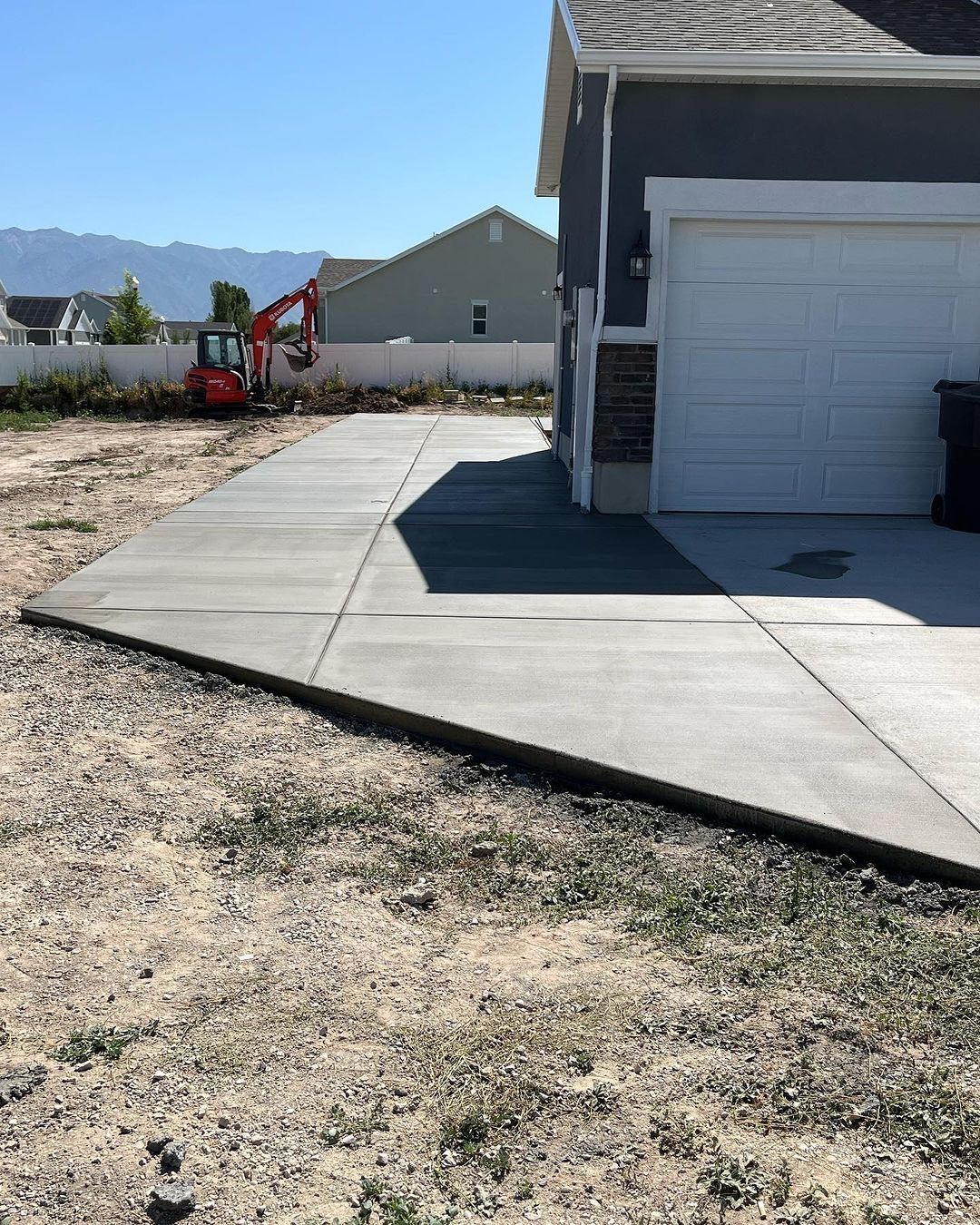 A concrete driveway is being built in front of a house.