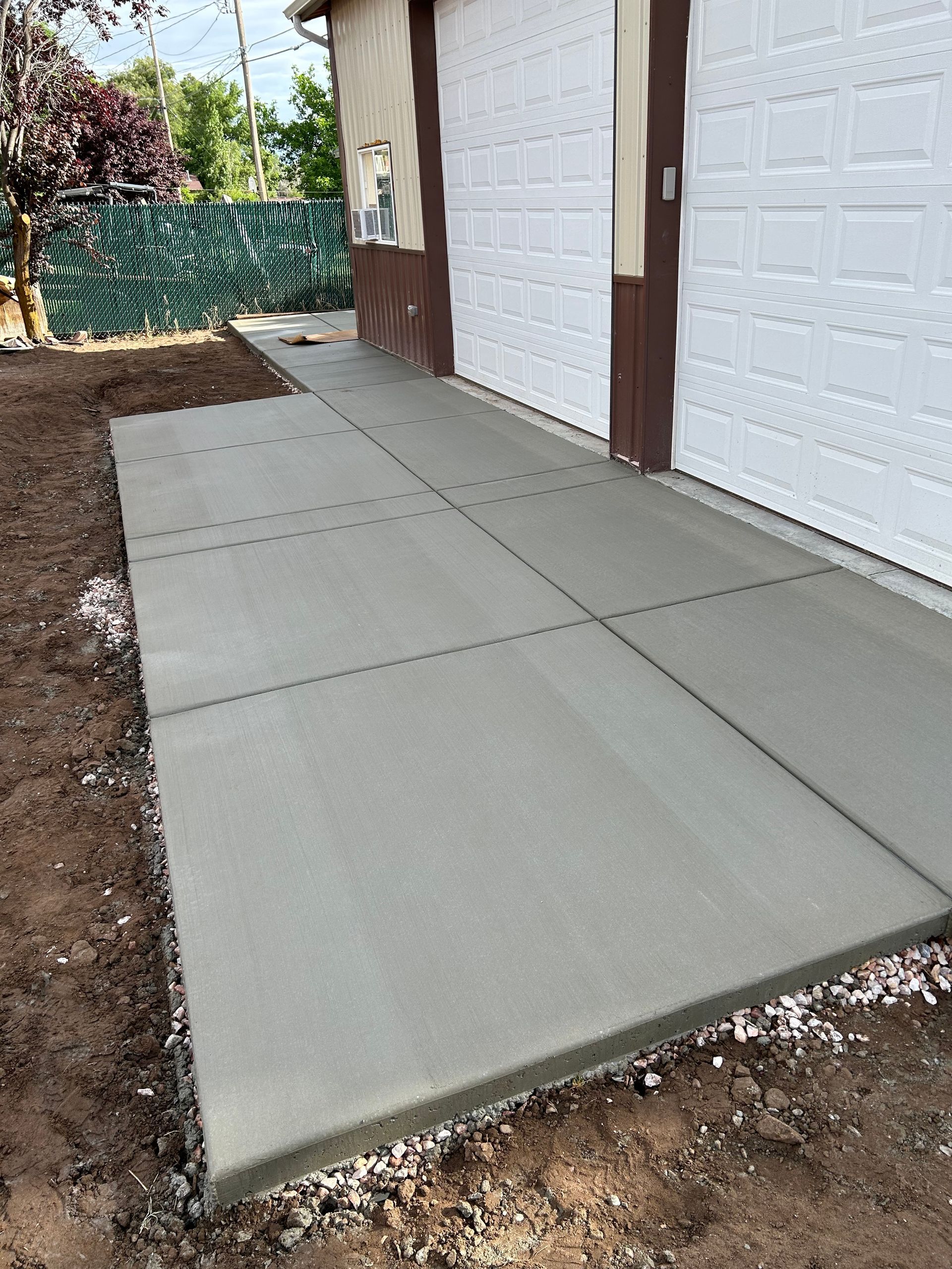 Concrete walkway beside garage doors under construction