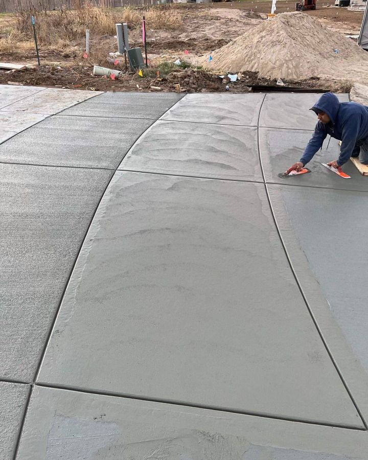 A man is working on a concrete driveway.