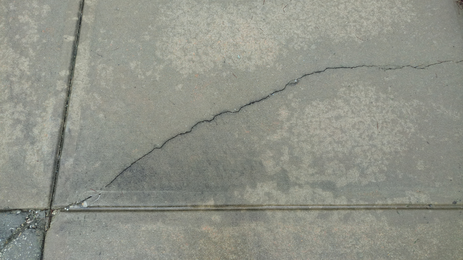 Concrete driveway with poor slope design causing water drainage issues