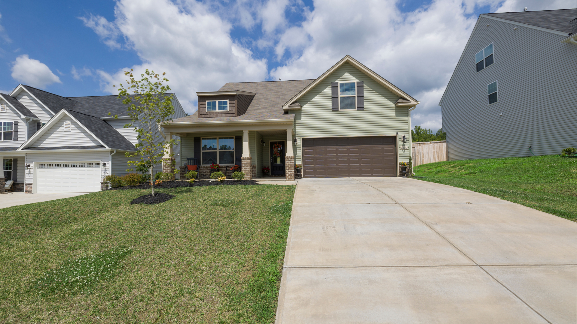 Concrete driveways in Syracuse Utah with a smooth modern finish in front of a residential home.