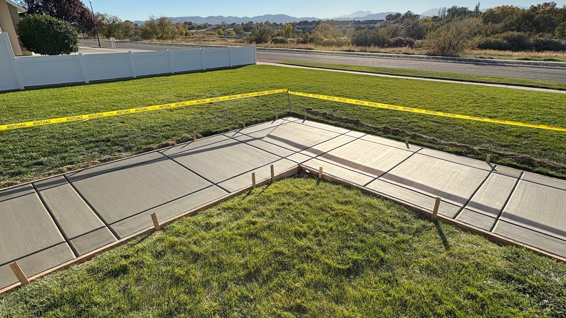 New concrete driveway approach meeting the curb at a Syracuse Utah home