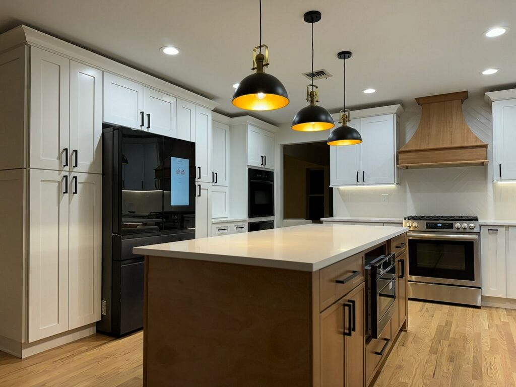 Modern kitchen with white cabinets, black appliances, island, and pendant lights