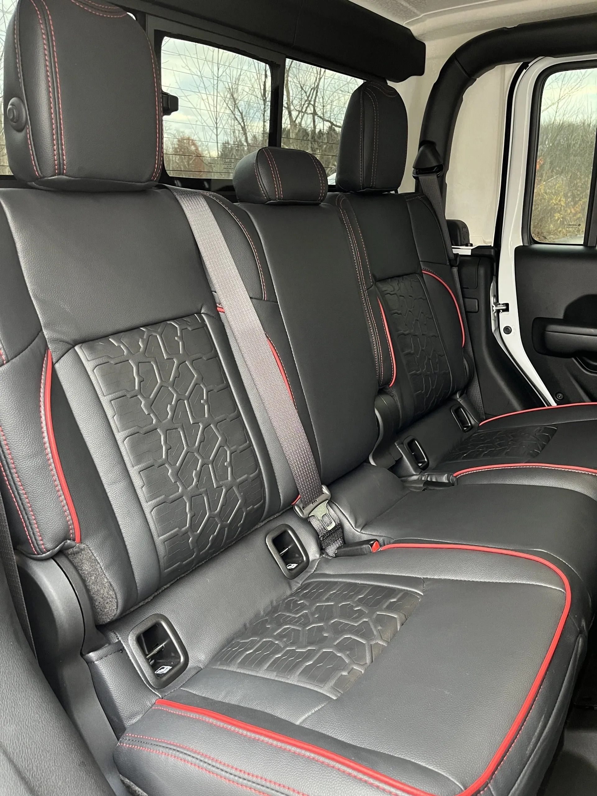 The back seats of a jeep wrangler are black and red