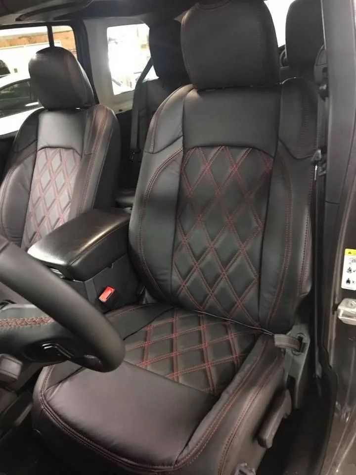 The front seats of a jeep wrangler are black and red
