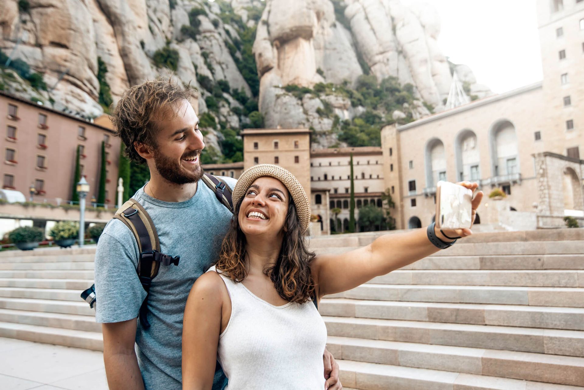 Un hombre y una mujer se toman un selfie frente a un edificio.