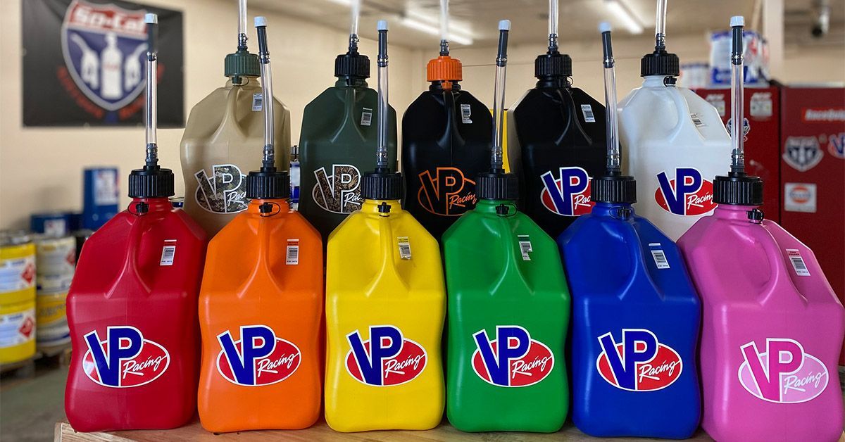 Row of colorful VP Racing gas cans in various colors with a logo, indoors.