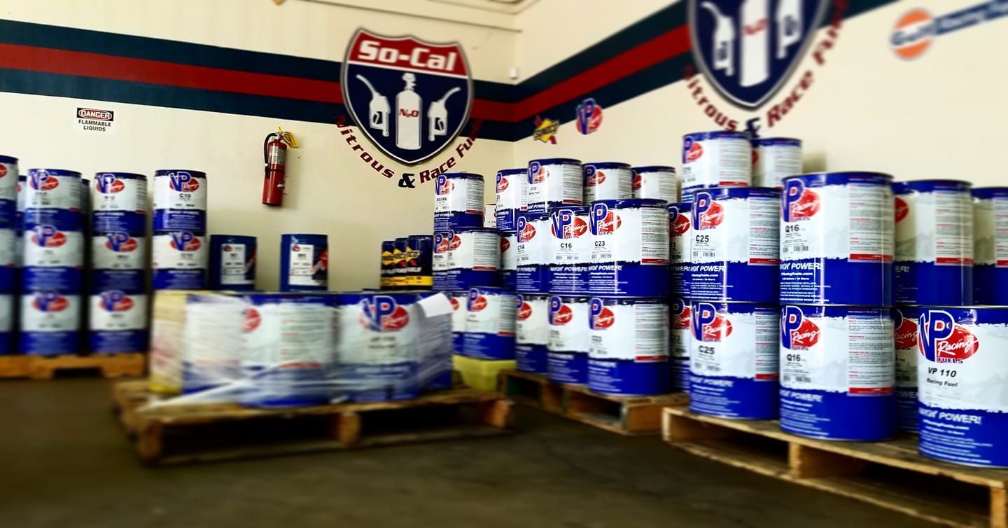 A warehouse interior showing rows of blue and white barrels labeled 