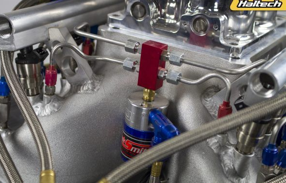Close-up of engine with fuel lines and components; metallic silver and blue colors are prominent.