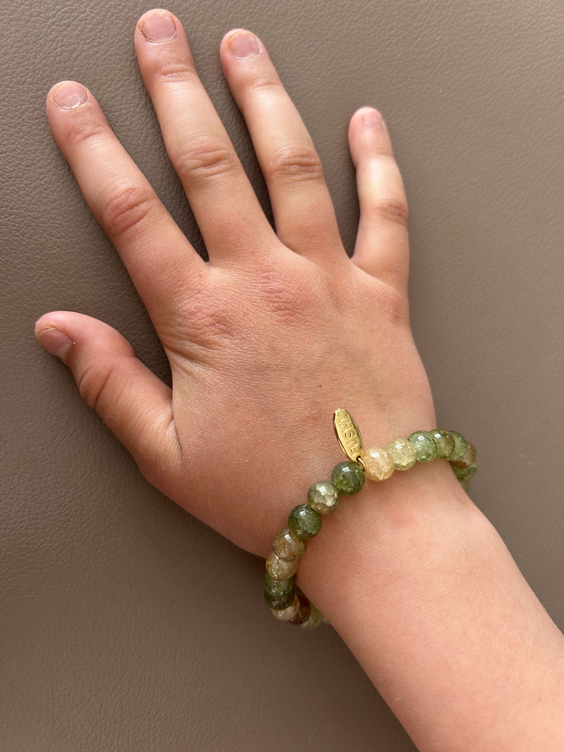 Glas kralenarmband groen met gouden bedeltje