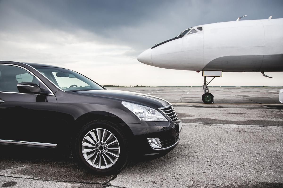 A limousine from Limo Hire Sunshine Coast is parked beside a private plane.