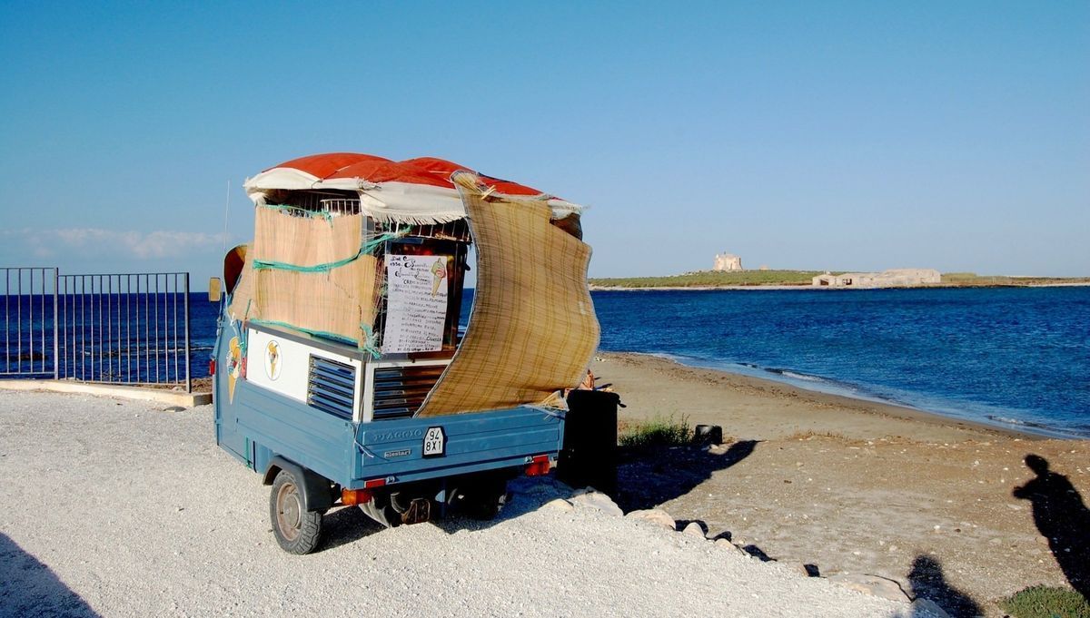 Blue cart loaded with straw by the sea on a sunny day