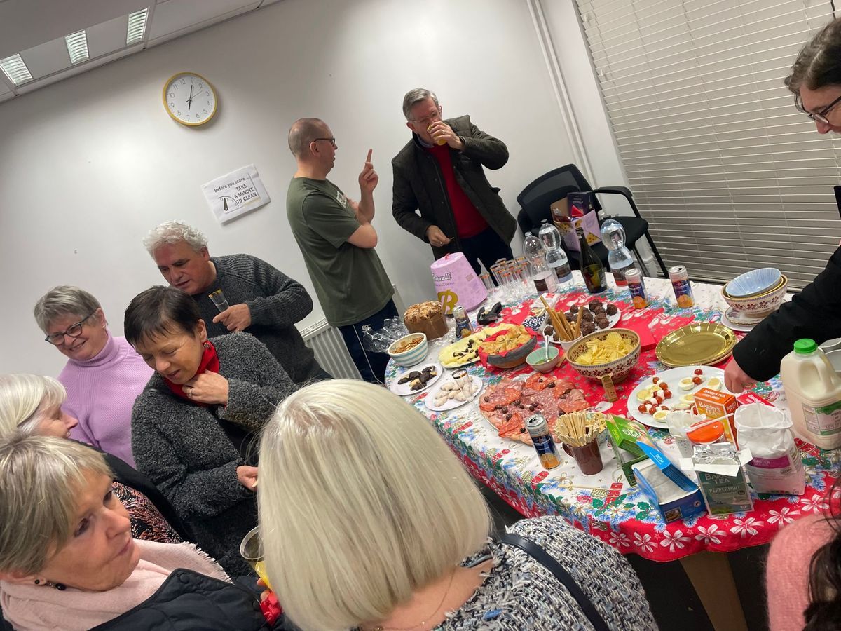 People gathered around a table with a colorful spread of snacks and drinks at a social event.