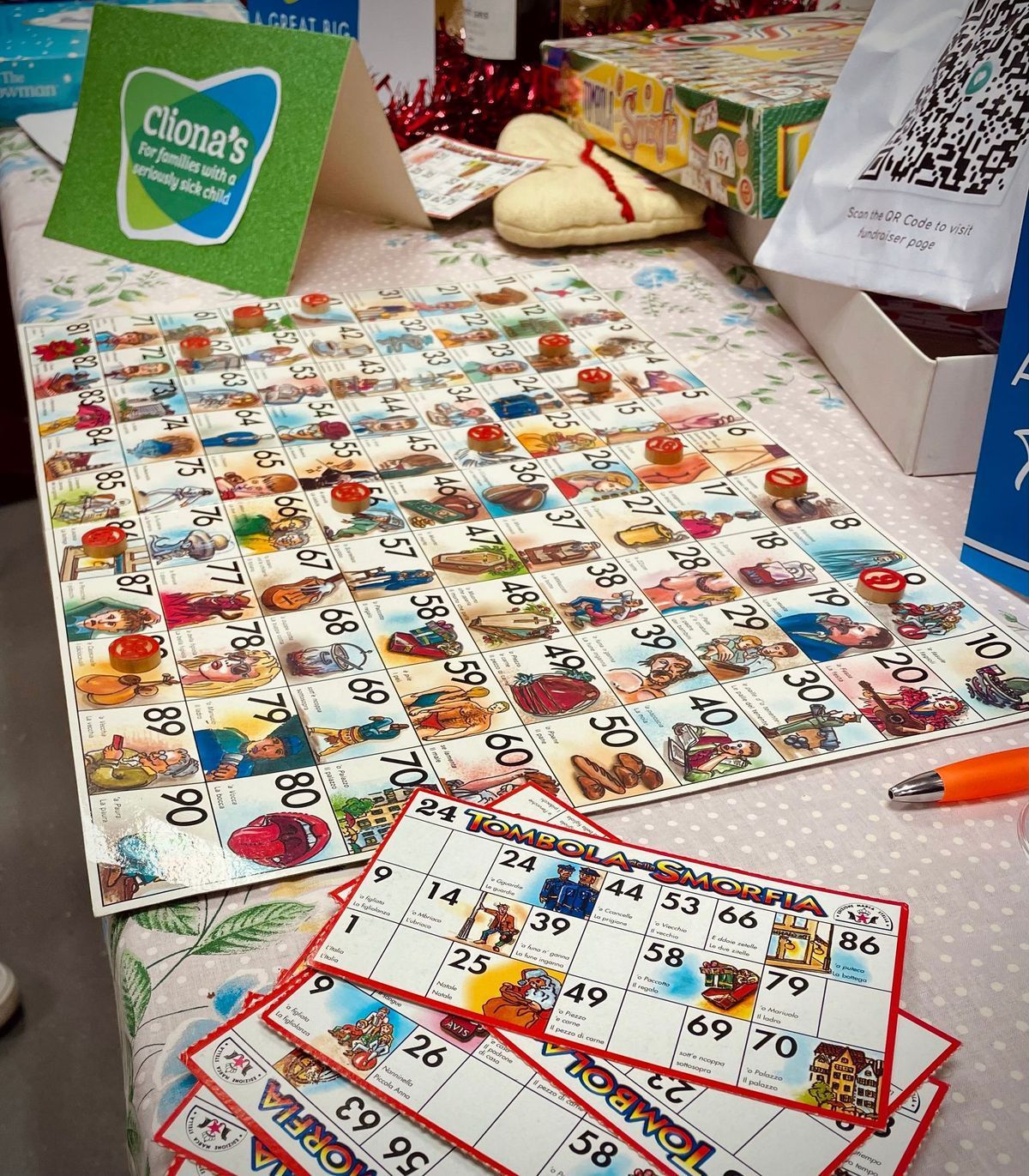 Close-up of a colorful numbered board game on a table with cards and boxes nearby.