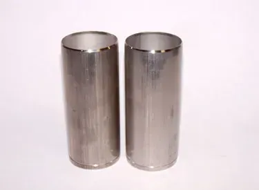 Two stainless steel cylinders are sitting next to each other on a white surface.