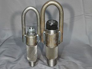 Two metal hooks are sitting on top of a metal barrel