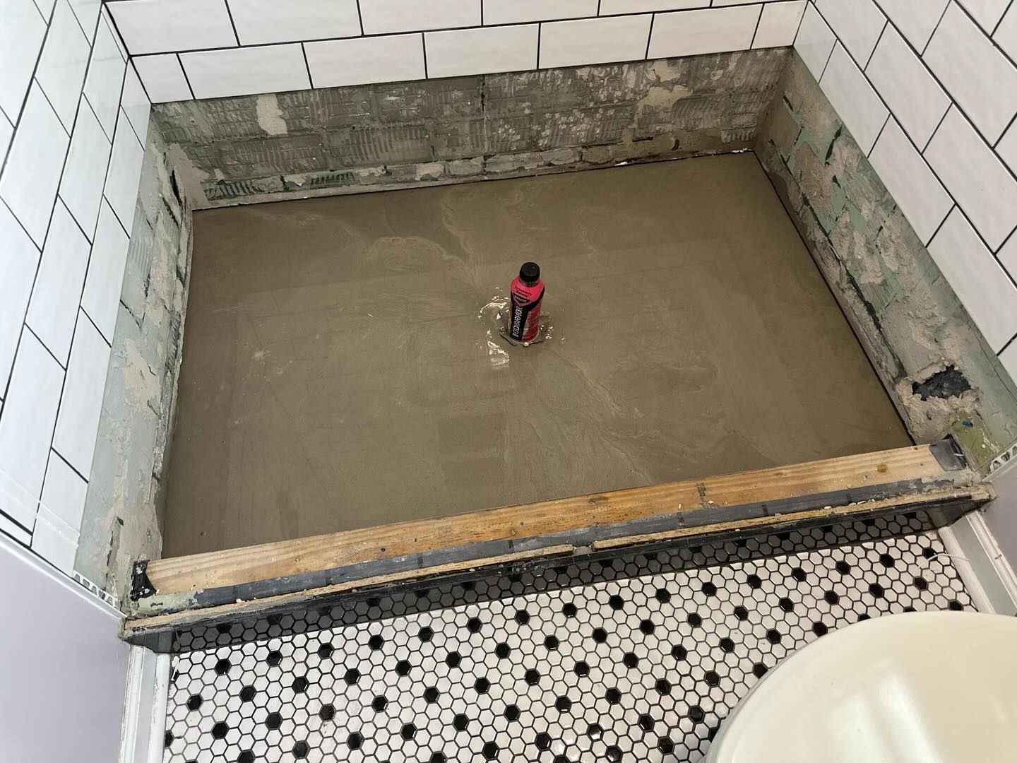Person stands in a flooded concrete pit under construction.