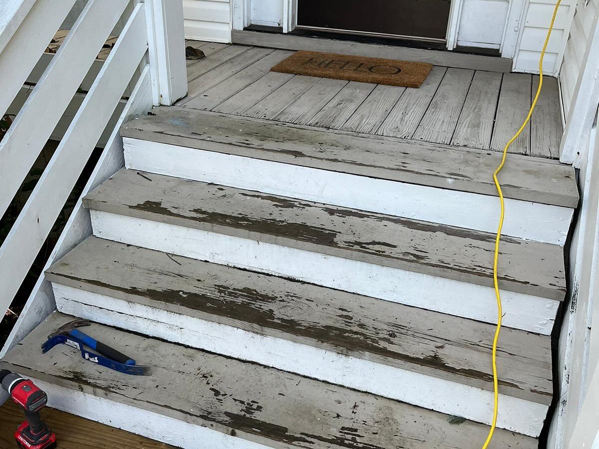 Dirty white porch steps with a yellow cord and tools on the left side
