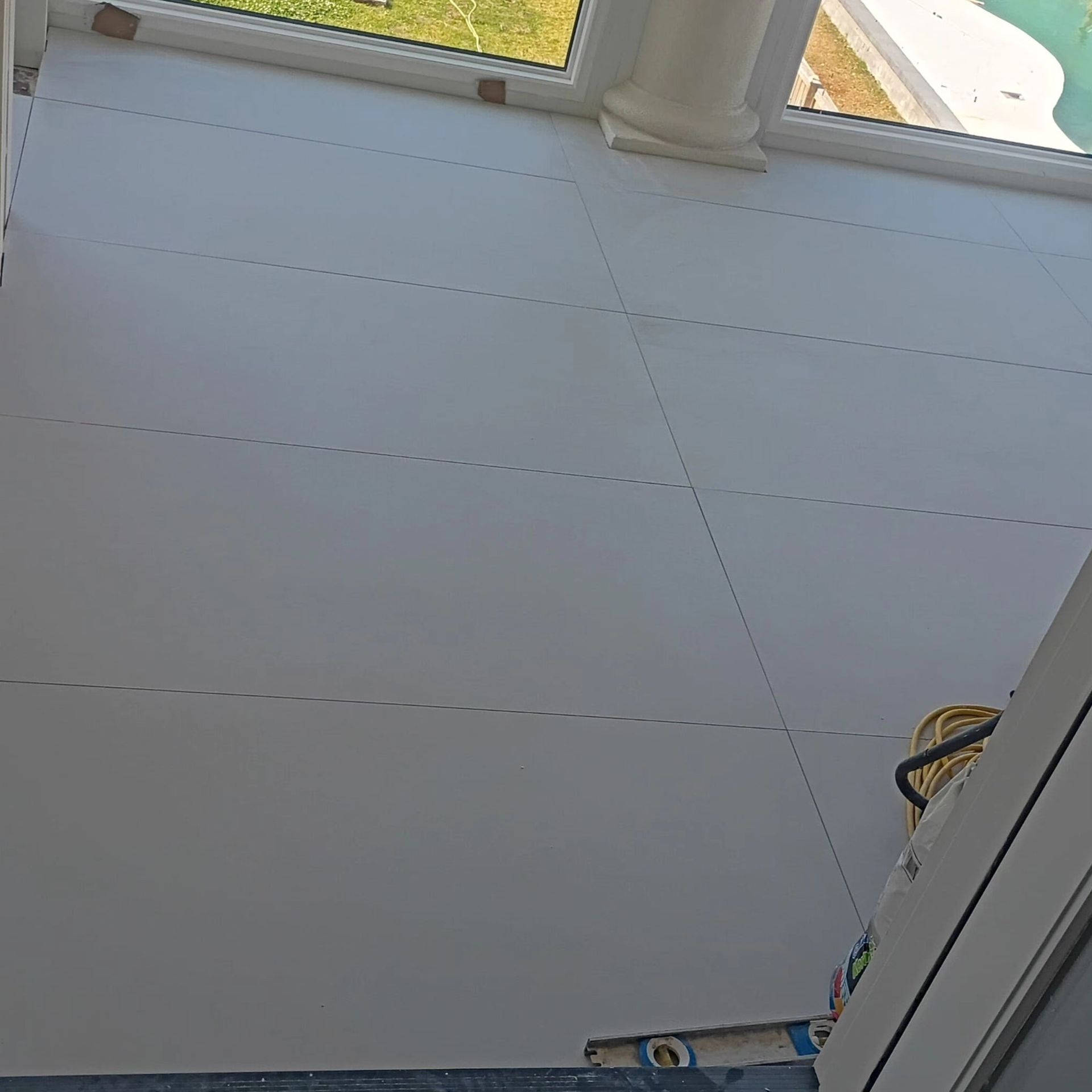 White tiled ceiling under a skylight, with a doorway edge and a small yellow object at the right.