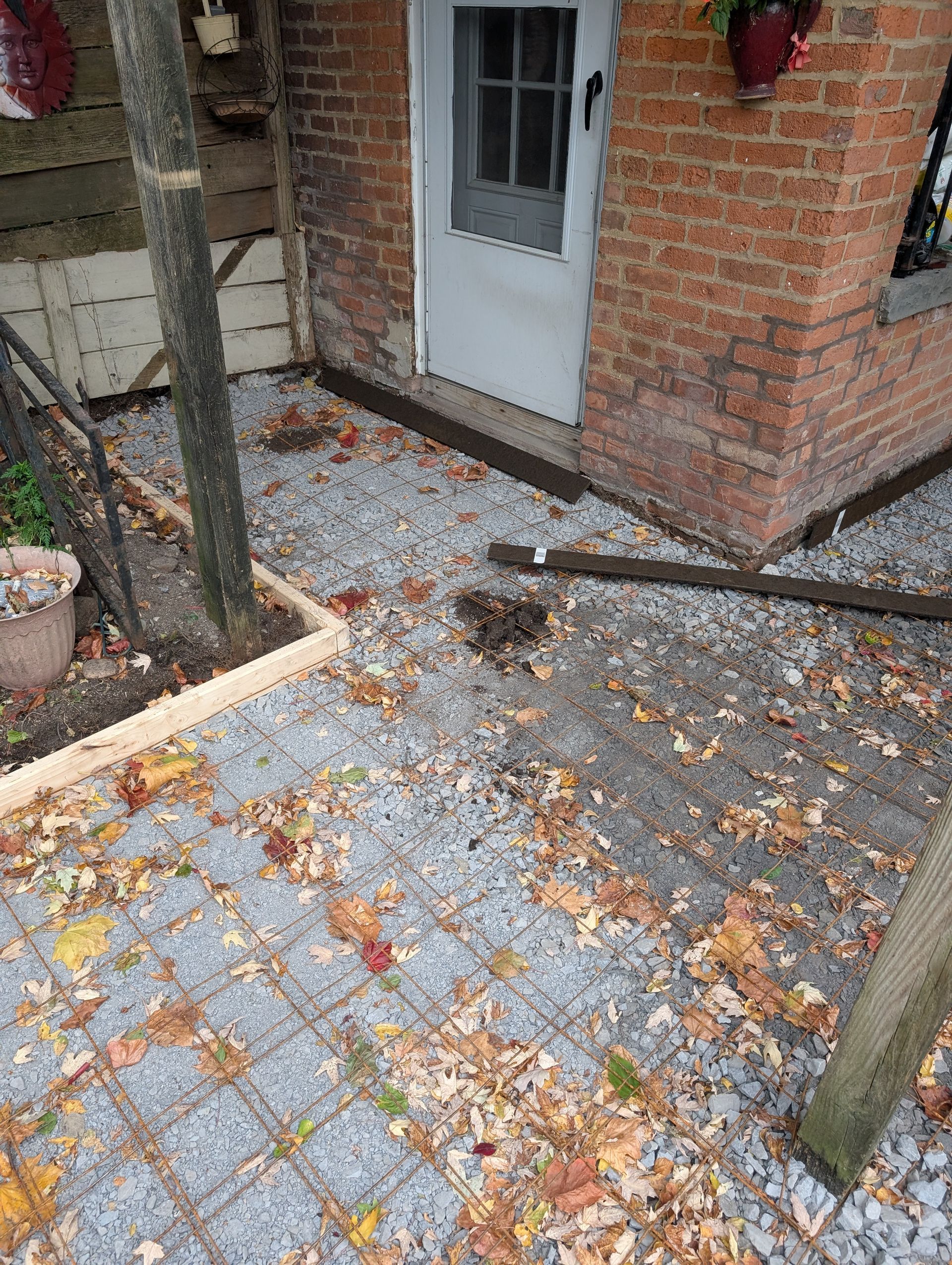 There are a lot of leaves on the ground in front of a brick building.
