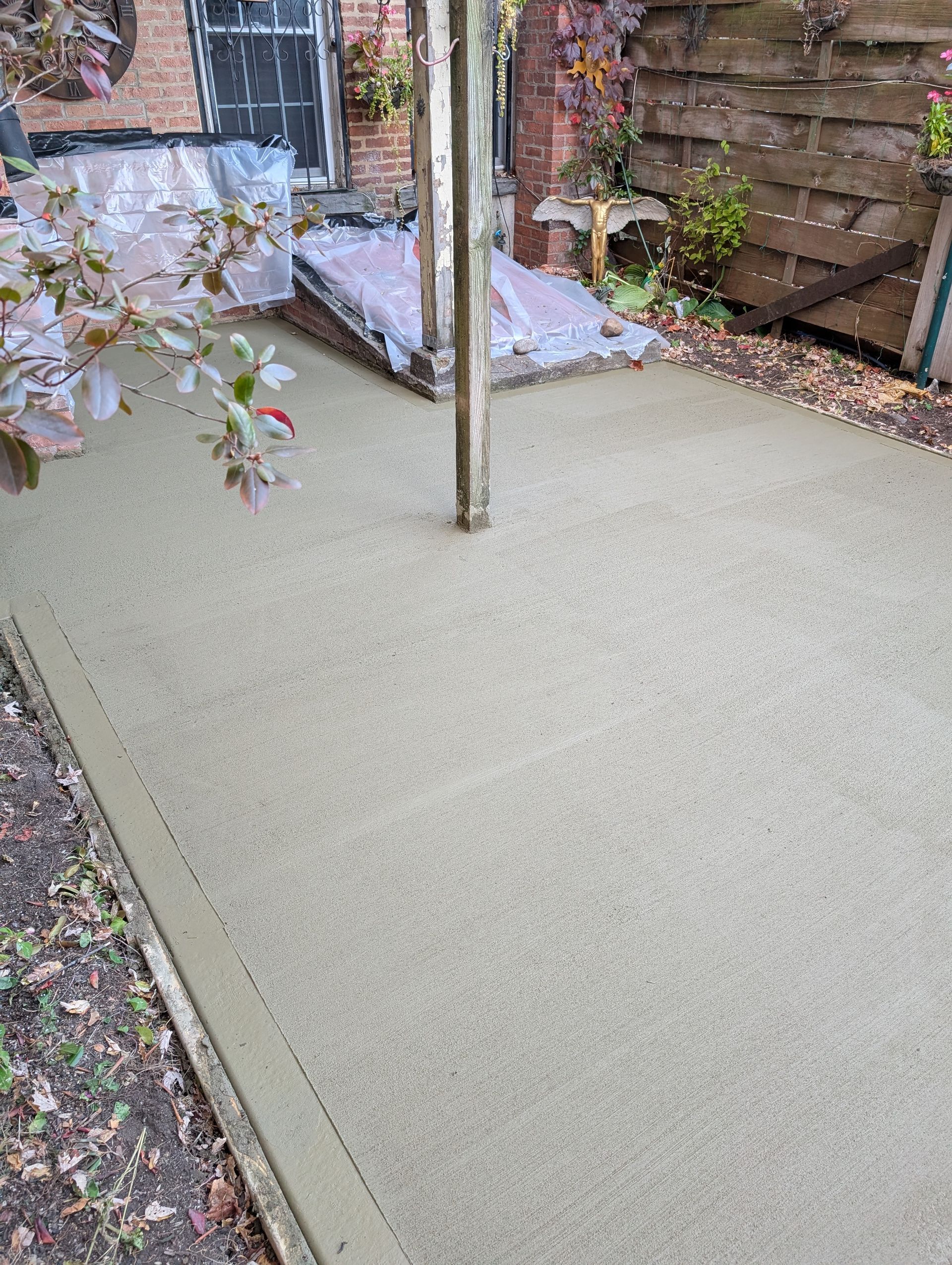A concrete patio with a wooden fence in the background.