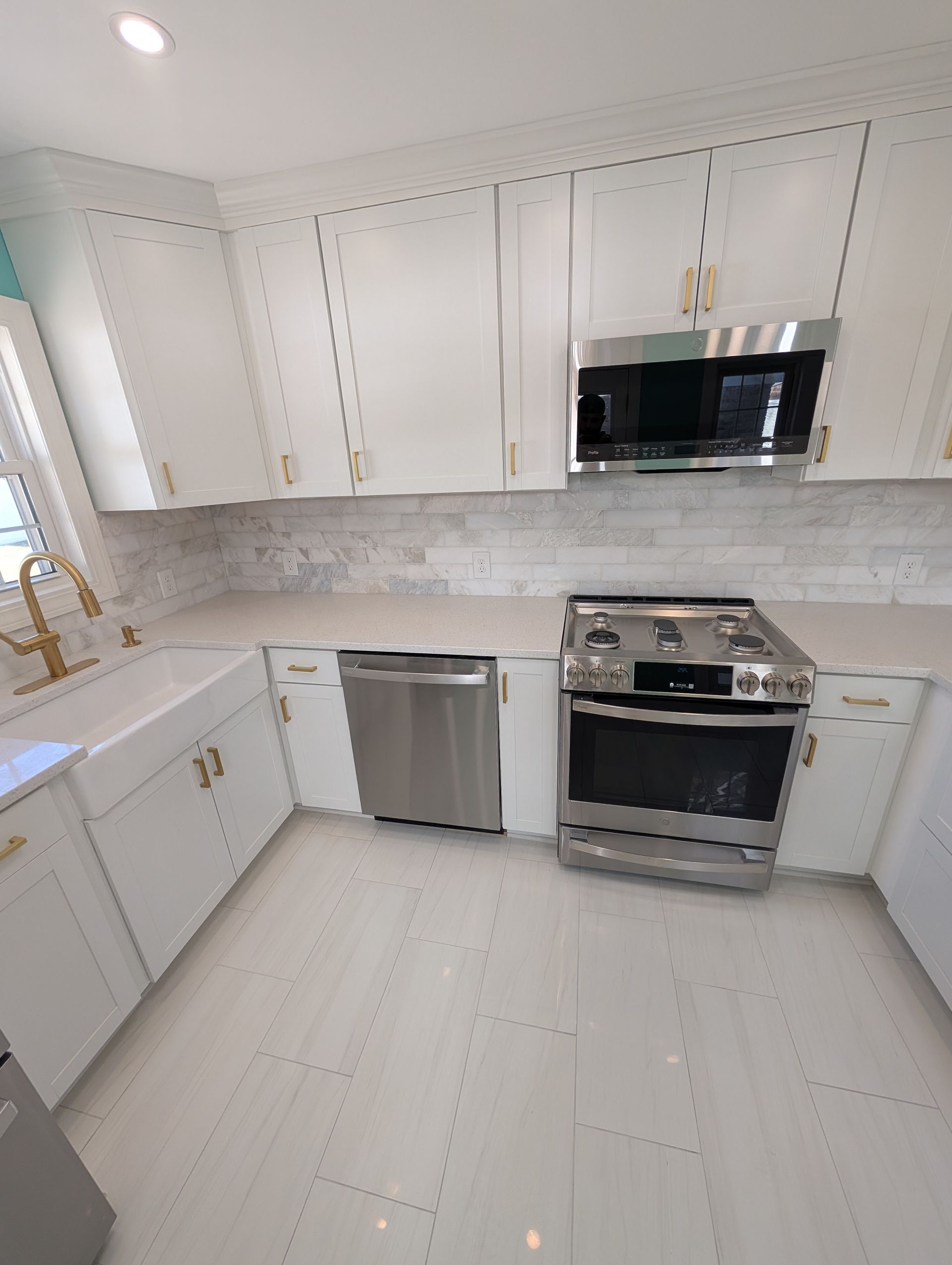 A kitchen with white cabinets and stainless steel appliances