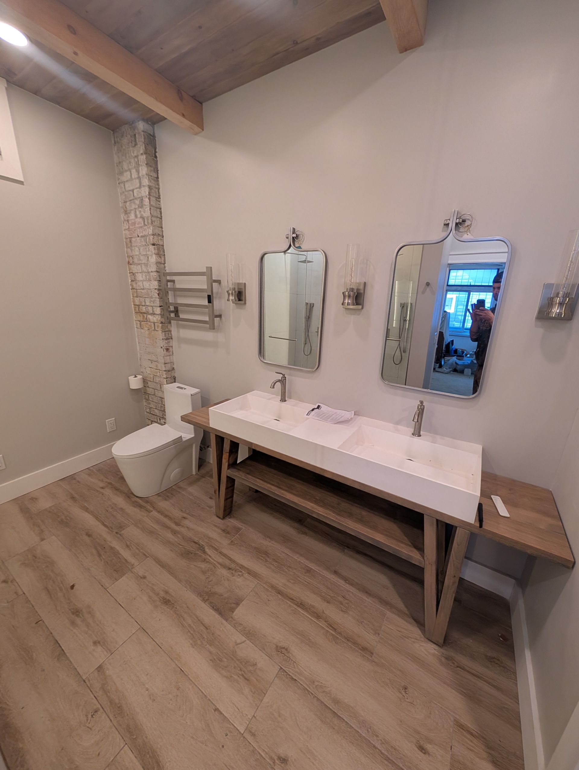 A bathroom with two sinks , a toilet , and two mirrors.