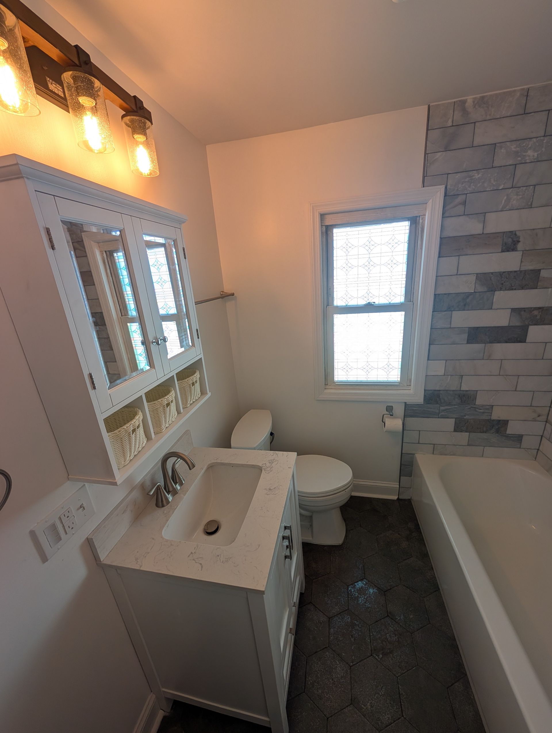 A bathroom with a toilet , sink , and bathtub.