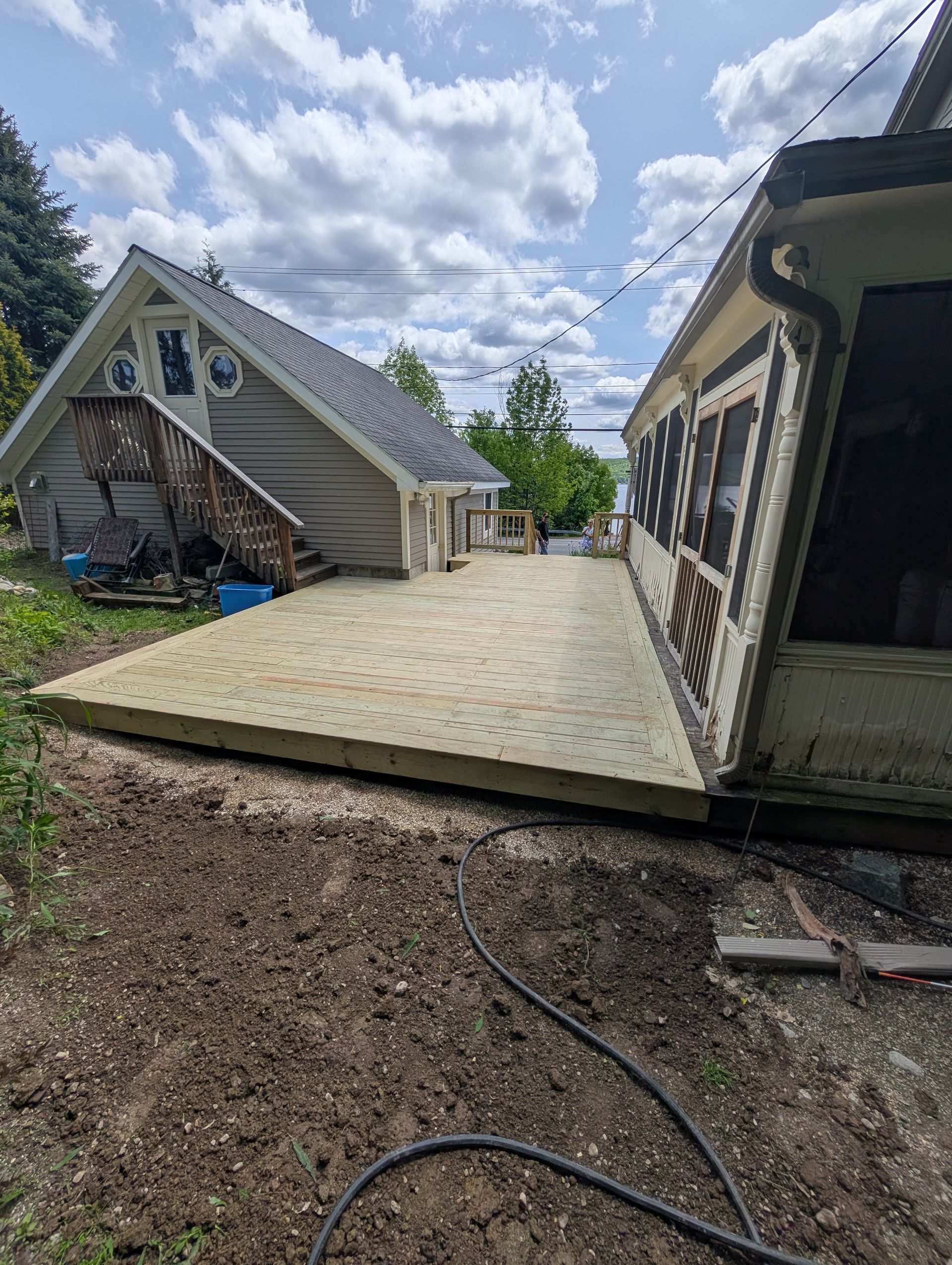 A wooden deck is being built in front of a house.