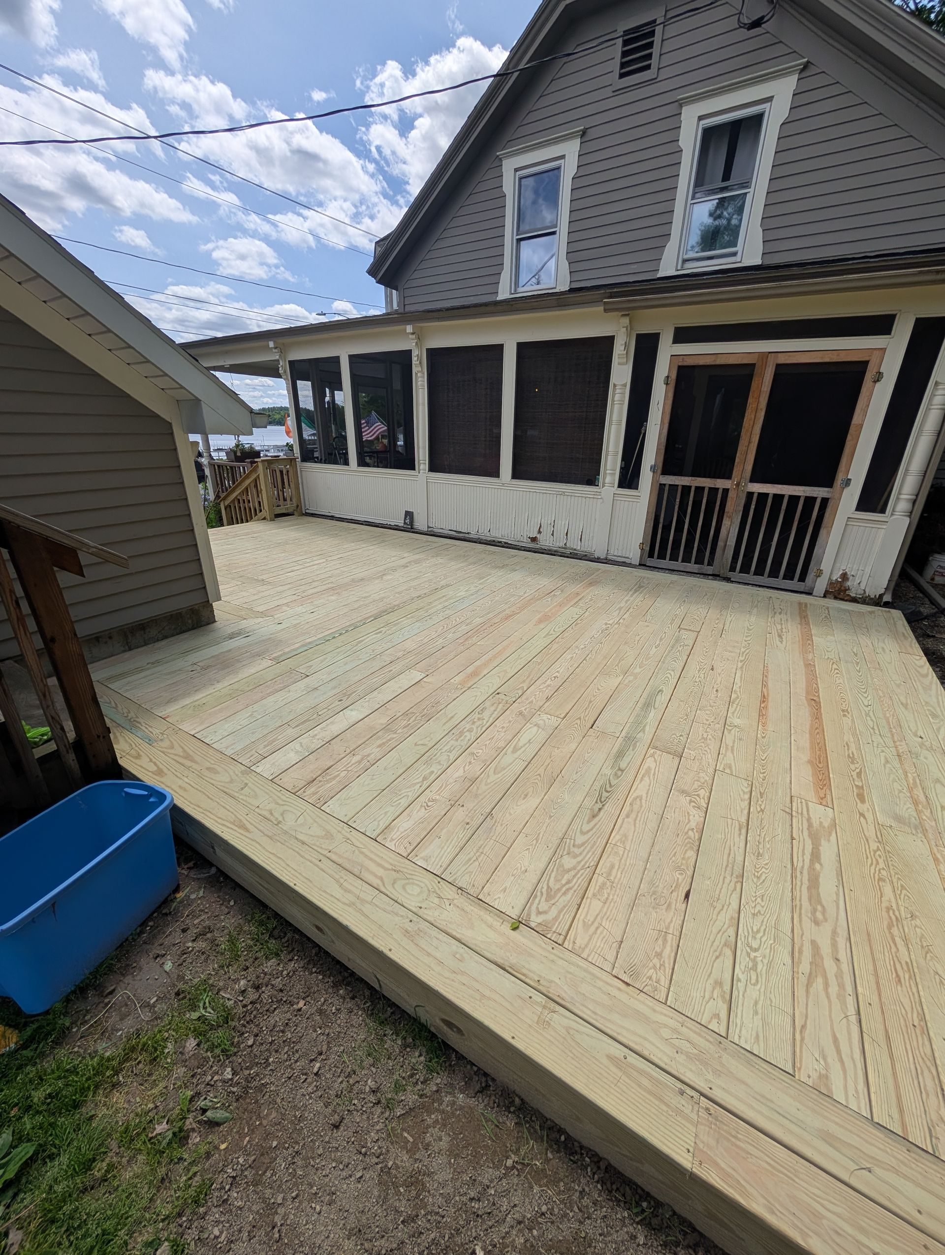 A wooden deck is being built in front of a house.