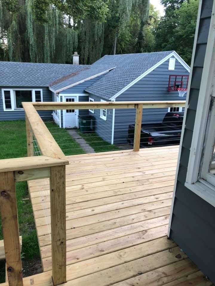 Wooden deck overlooking neighboring houses with gray siding and a small balcony