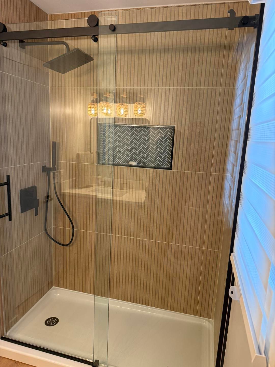 Modern walk-in shower with bamboo screen, rainfall showerhead, and white tub floor