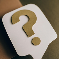 Gold question mark on a white speech bubble icon