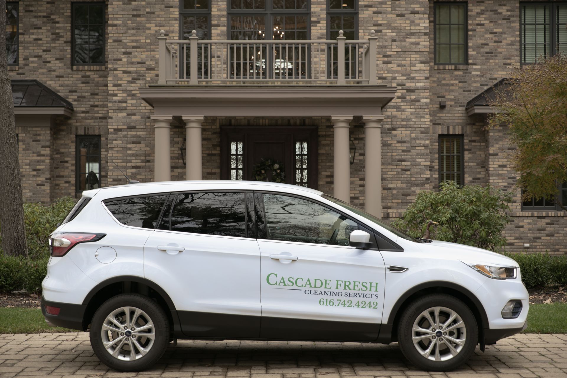 White SUV parked in front of a stone house with
