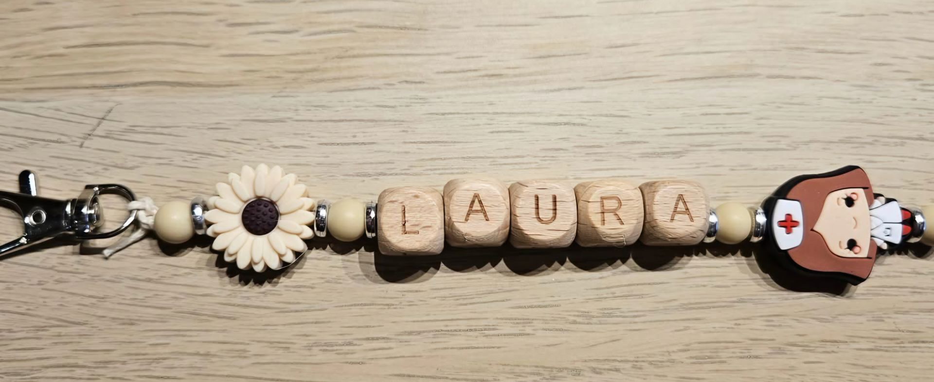 Houten sleutelhangertje met kralen waarop 