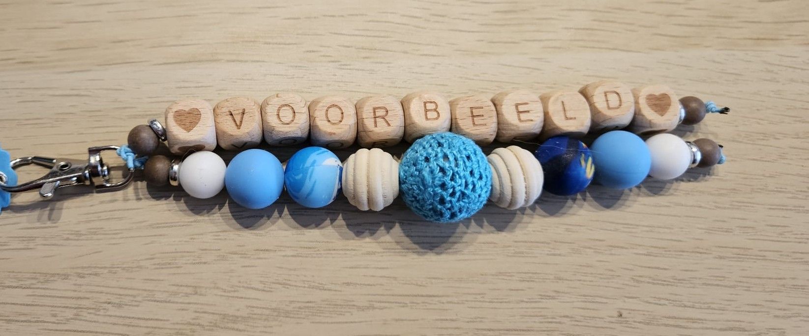 Houten kralenarmband met blauwe en witte kralen die samen het woord 