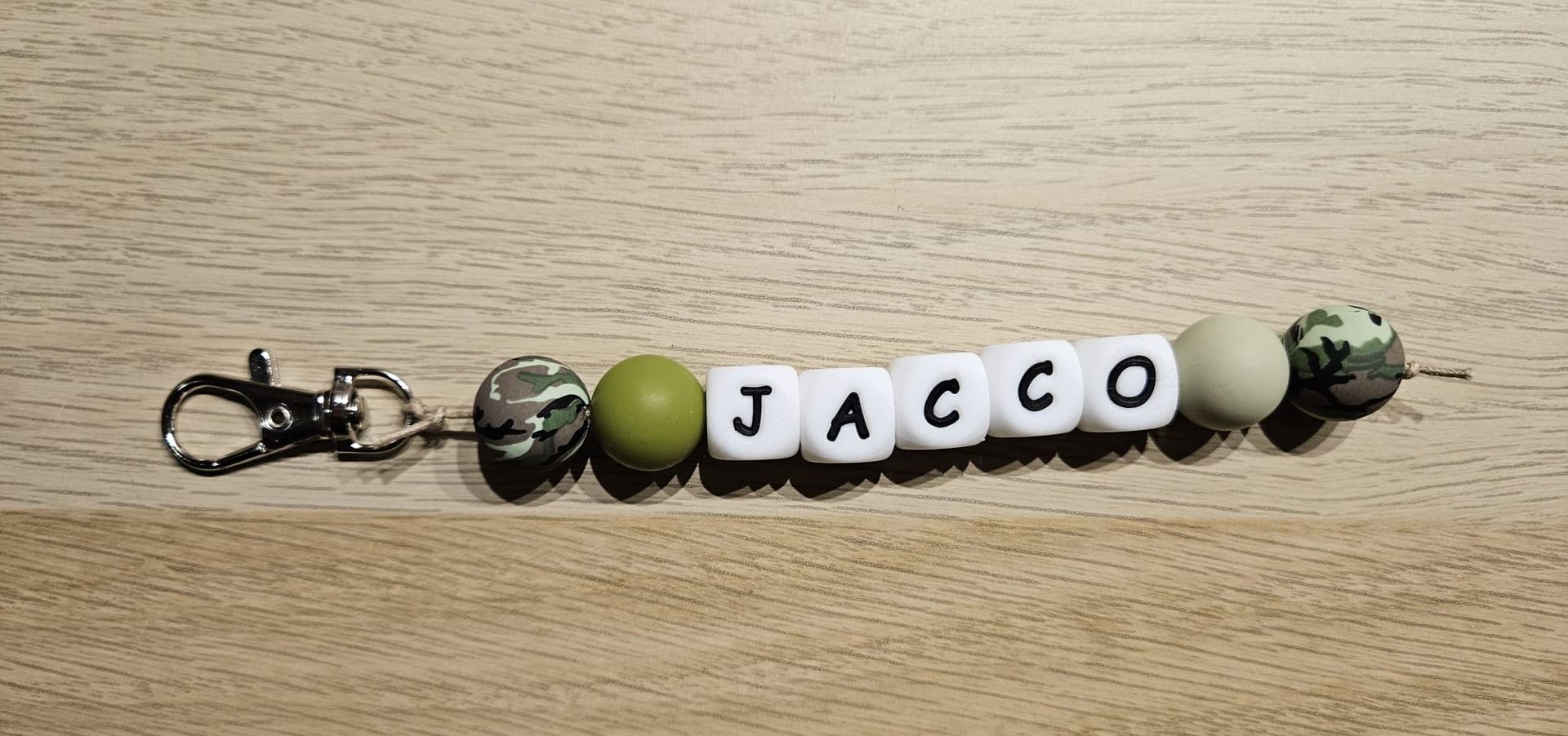Sleutelhanger met witte letterkralen die 