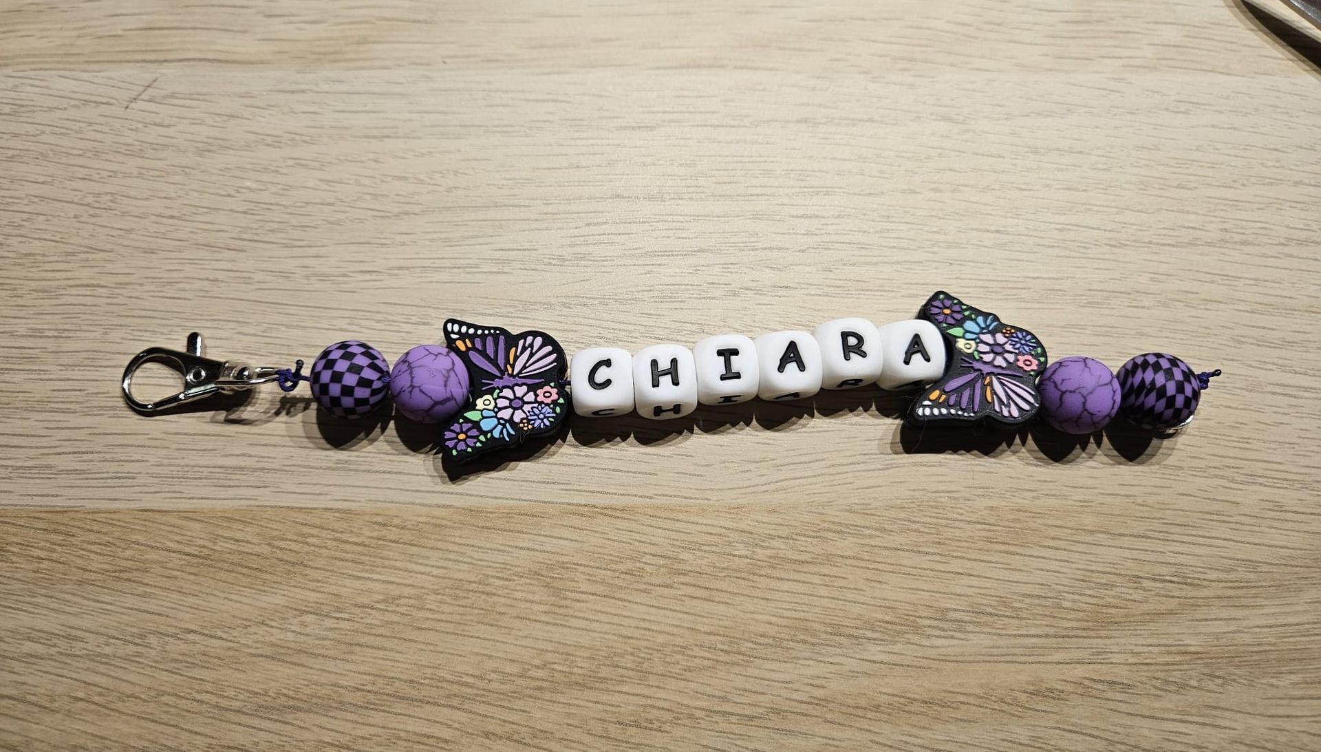 Paarse kralenarmband met een vlinder en naamkralen die samen 