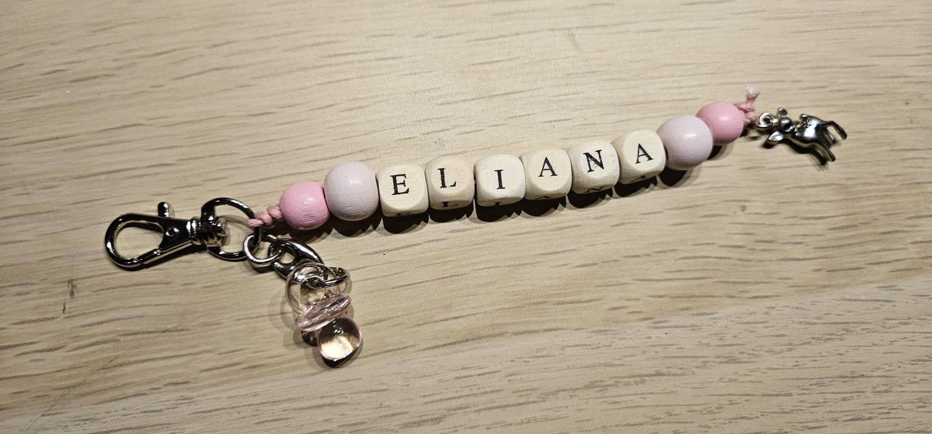 Roze en witte kralenarmband sleutelhanger met de tekst 