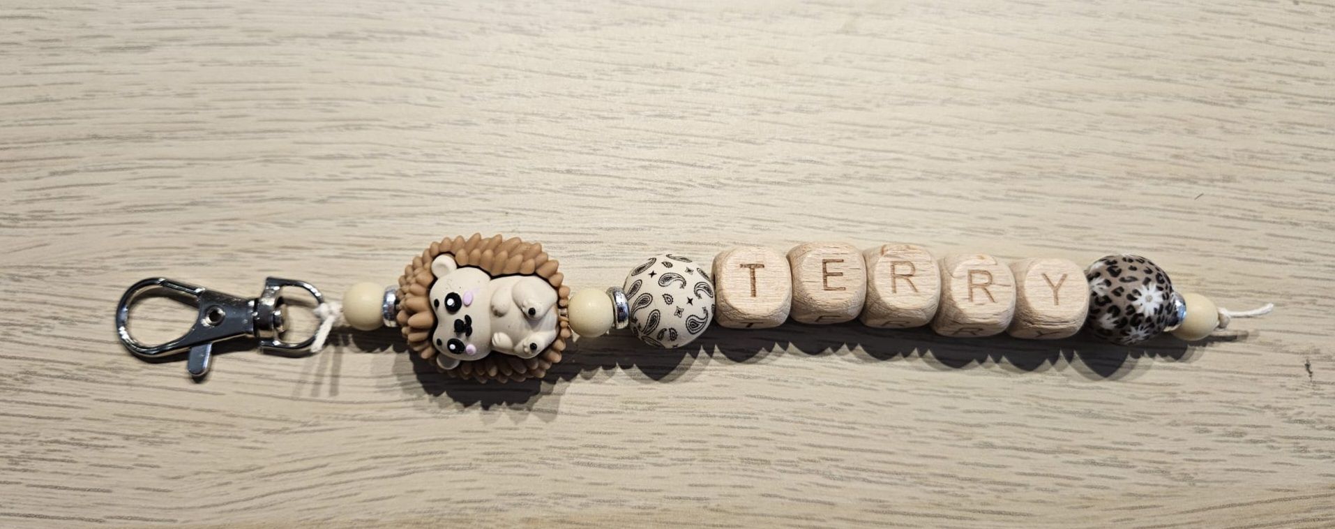 Sleutelhangertje met kralen, een pootafdrukje en de letters 