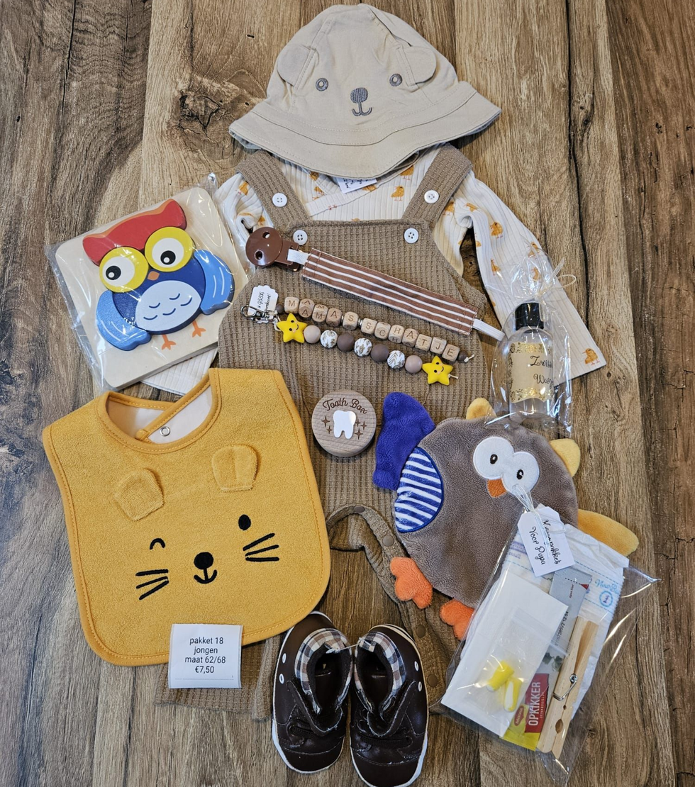 Een platte legging van babykleding en -accessoires in grijs, mosterdgeel en zwart-wit op een houten vloer.