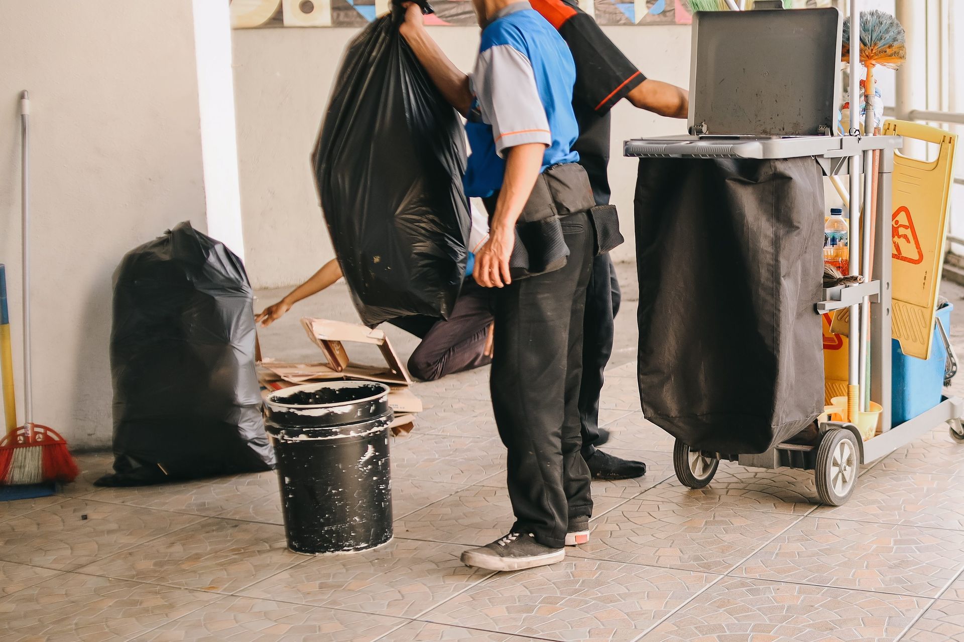 a man is carrying a bag of trash in a room