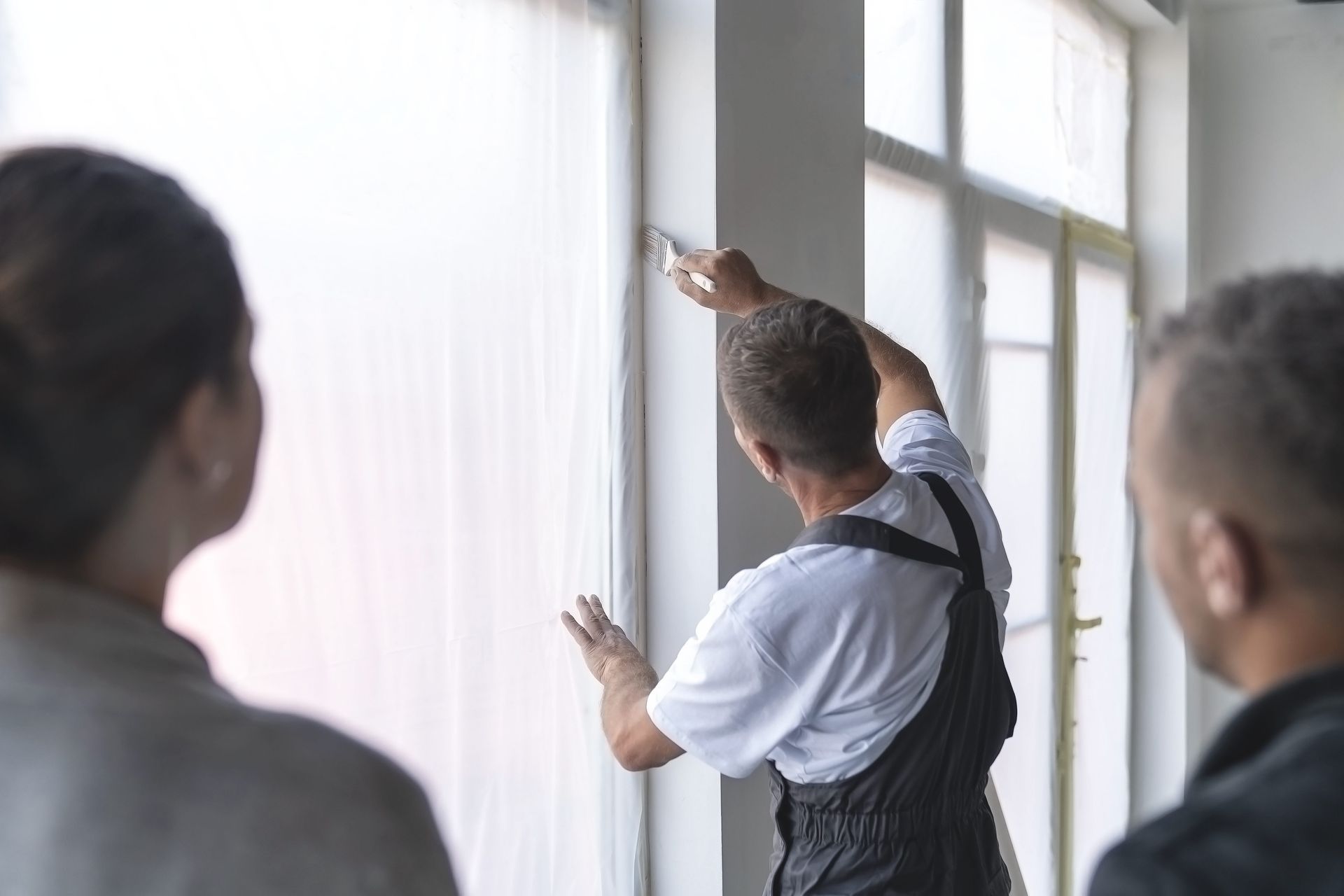 a man is installing a window while a woman watches