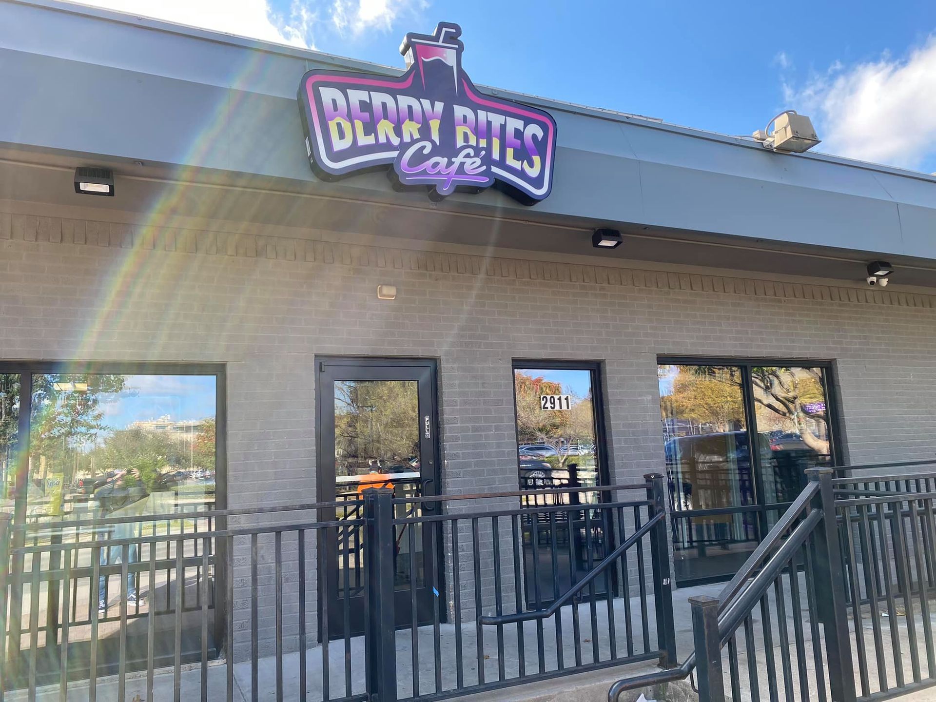 A brick building with a sign that says `` berry bites cafe '' on it.