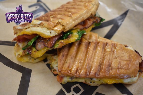 A close up of a sandwich on a plate with a berry bites logo on it.