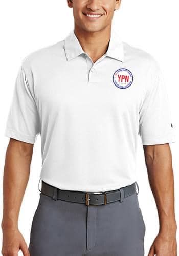 A man is wearing a white polo shirt and gray pants.