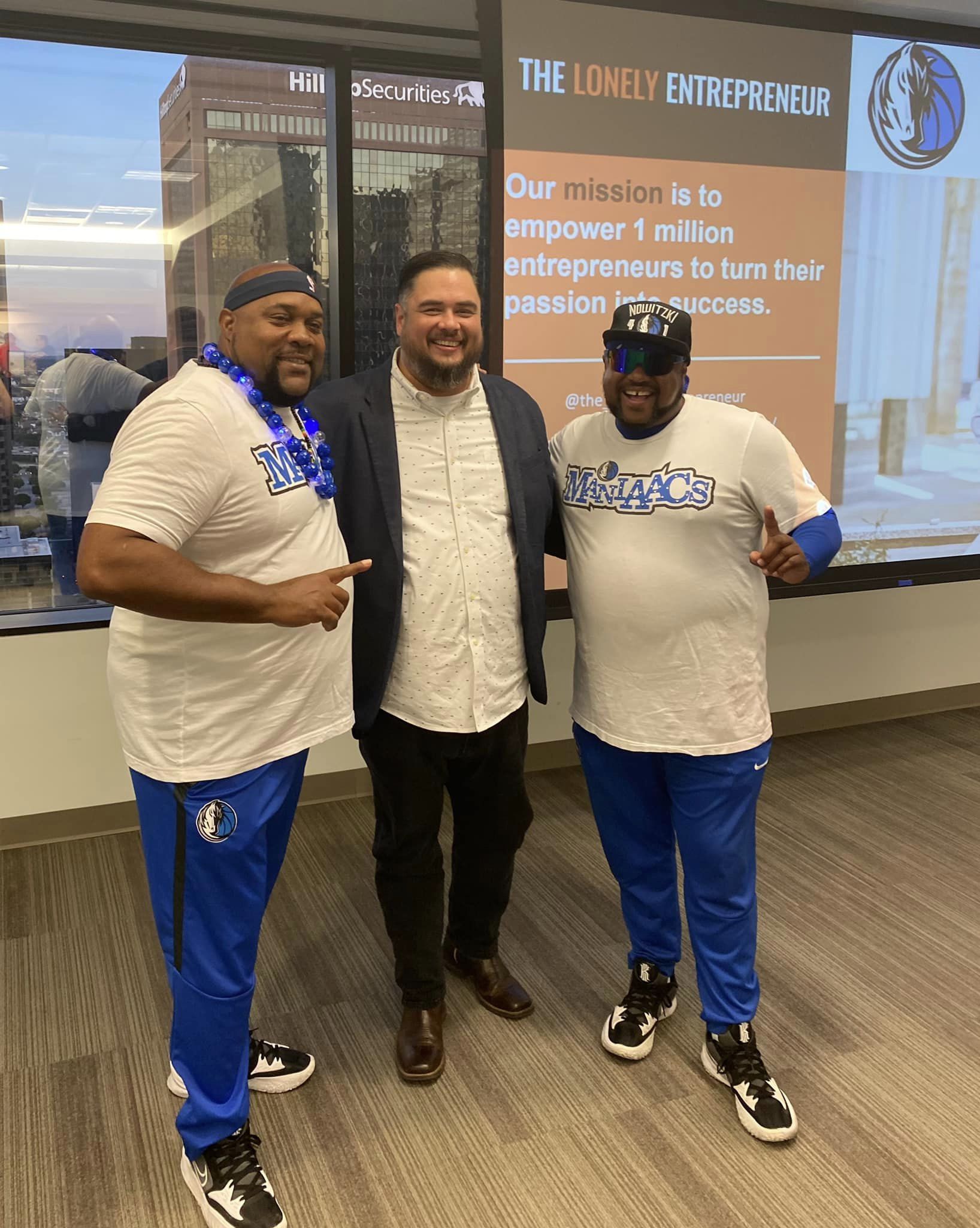 Award Winning Designer Bobby Robinson with the Dallas Maniaacs Three men are posing for a picture in front of a window.