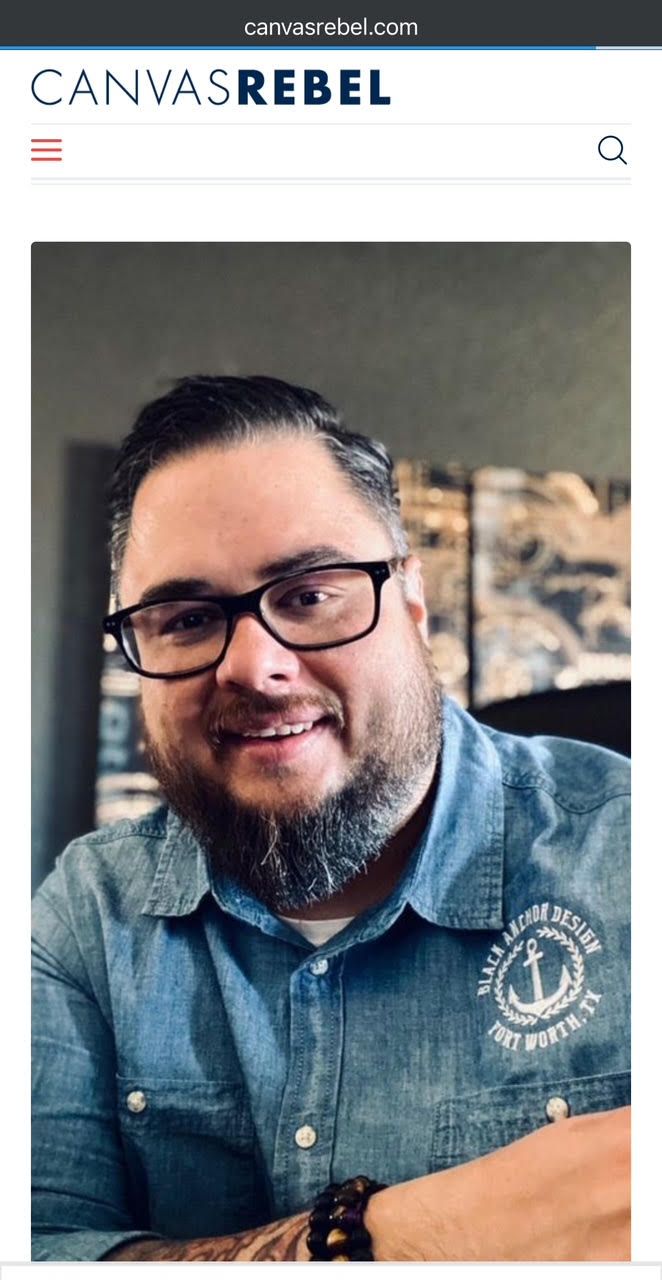 A man with glasses and a beard is sitting at a table.